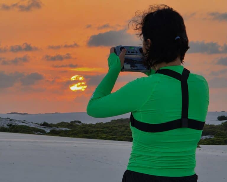 Producer Jihee Yeon filming the Lençóis Maranhenses dunes under an orange sky with a drone controller