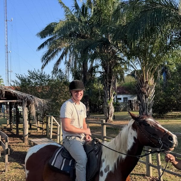 Sally's son riding a pinto horse at the ranch