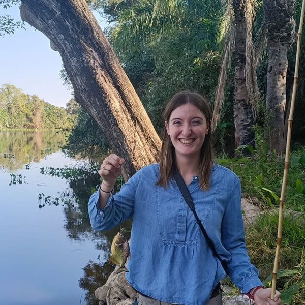 Sally's daughter holding a fish caught in the river