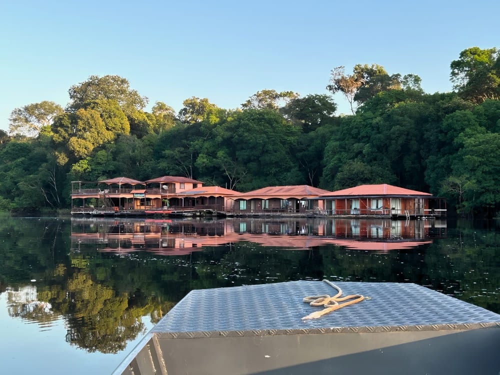 Eco floating lodge with red roofs reflected on the Rio Negro in the Brazilian Amazon