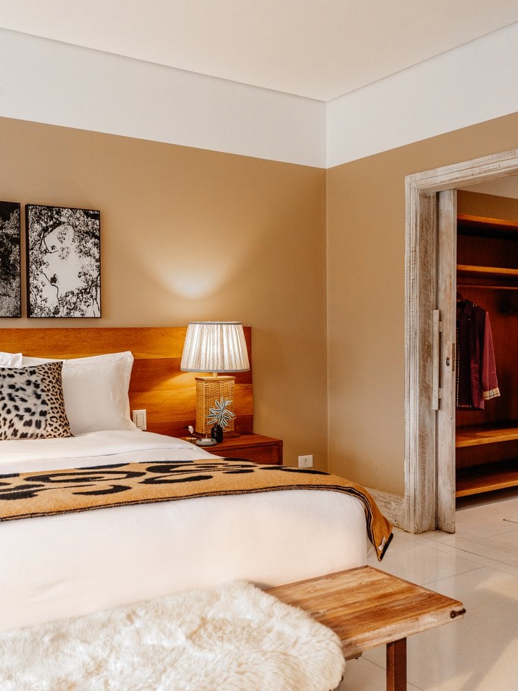 Suite bedroom at Casa Caiman with a double bed, wooden headboard and walk-in closet