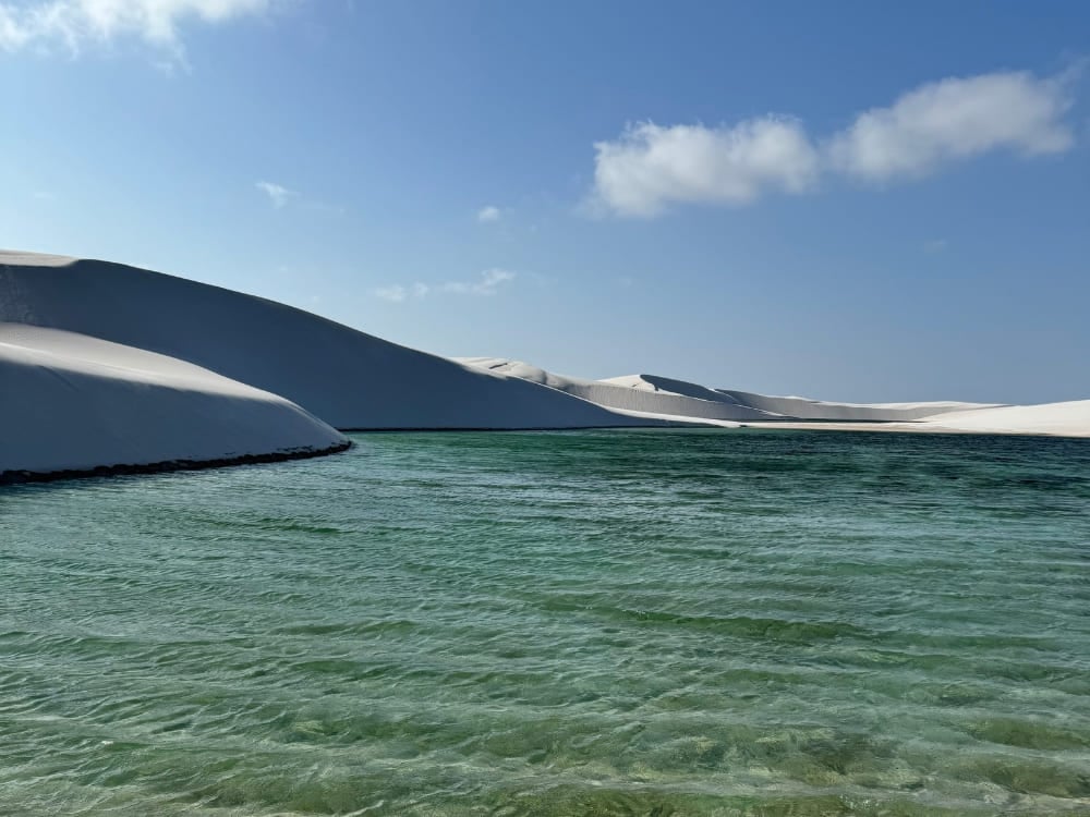 Extensive white sand dunes meet a seasonal crystal-clear green lagoon in the Lencois Maranhenses National Park. Extensive white sand dunes meet a seasonal crystal-clear green lagoon in the Lencois Maranhenses National Park.