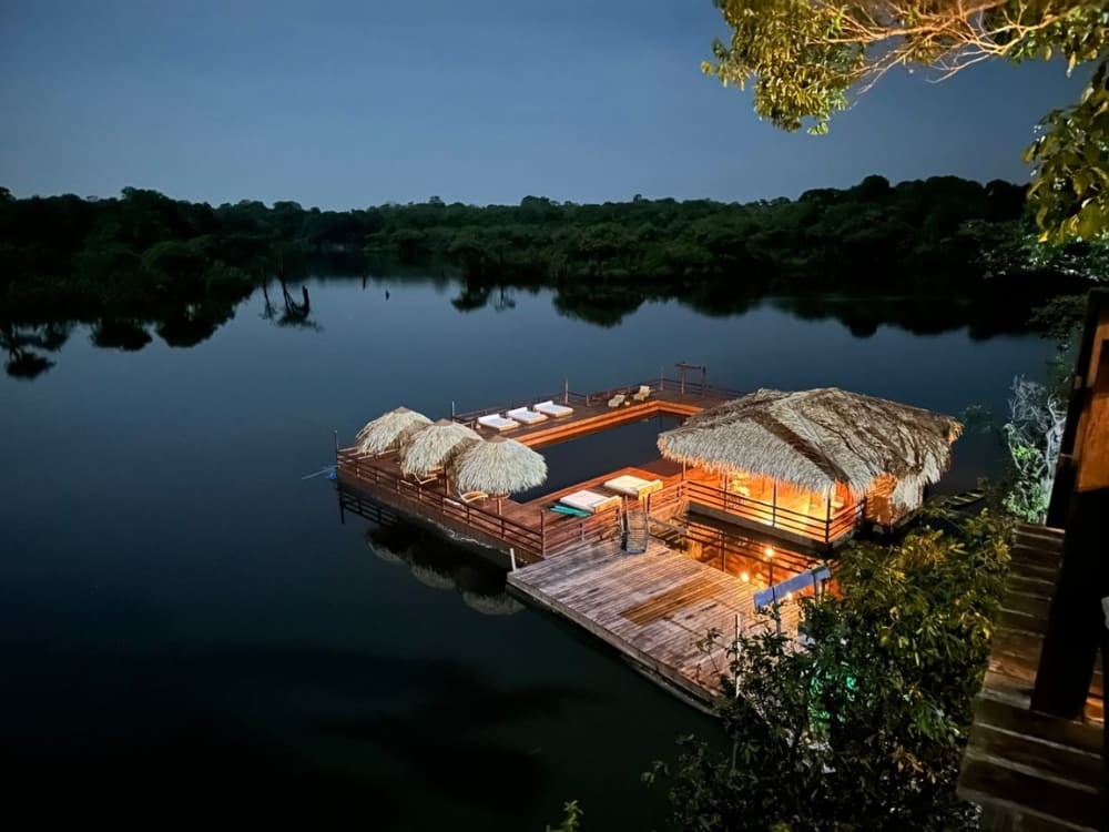 . A floating deck and pool illuminated at night at Juma Amazon Lodge in the Amazon rainforest.