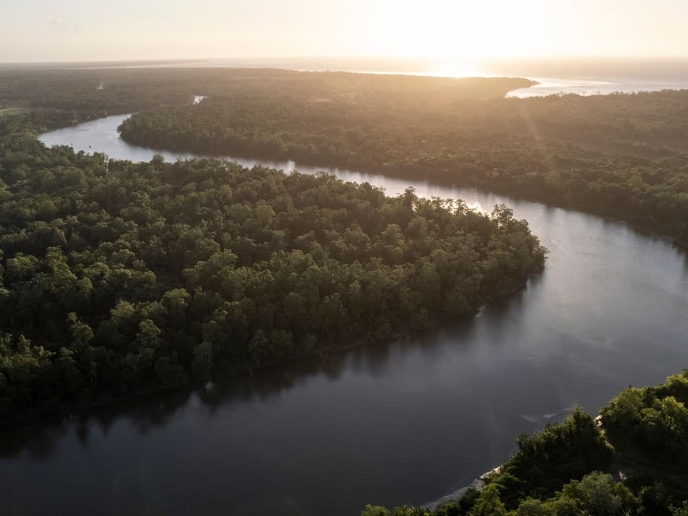 Aerial view of the Amazon River winding through the dense rainforest in Brazil during a golden sunrise. Aerial view of the Amazon River winding through the dense rainforest in Brazil during a golden sunrise.