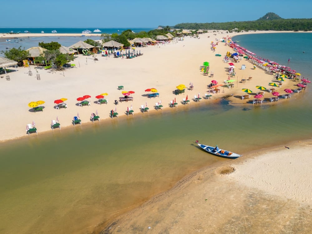 White sand beach filled with colorful umbrellas along the greenish waters of the Tapajós River in Alter do Chão. White sand beach filled with colorful umbrellas along the greenish waters of the Tapajós River in Alter do Chão.