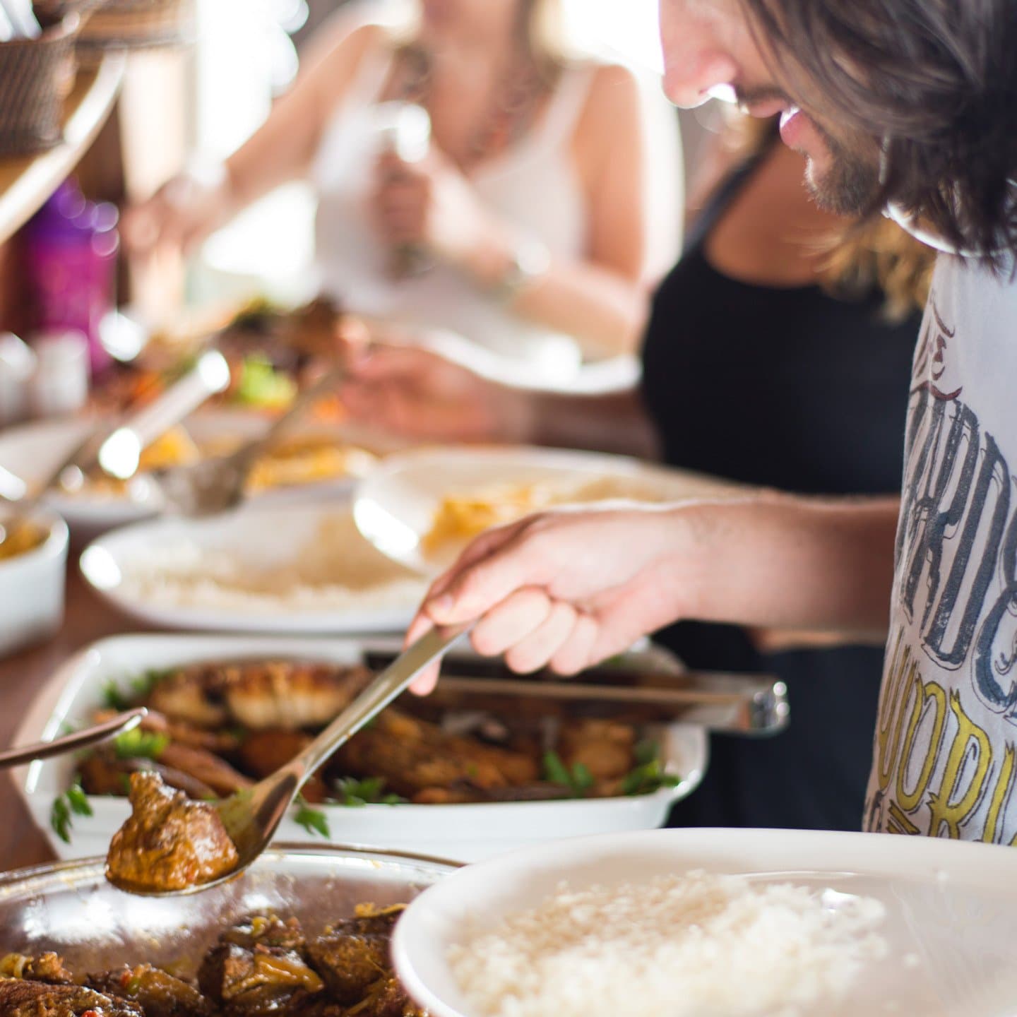 Good food is part of the adventure, not a break from it. Travelers serving themselves from a spread of hot dishes and rice at an all-inclusive Amazon jungle cruise Brazil meal on board