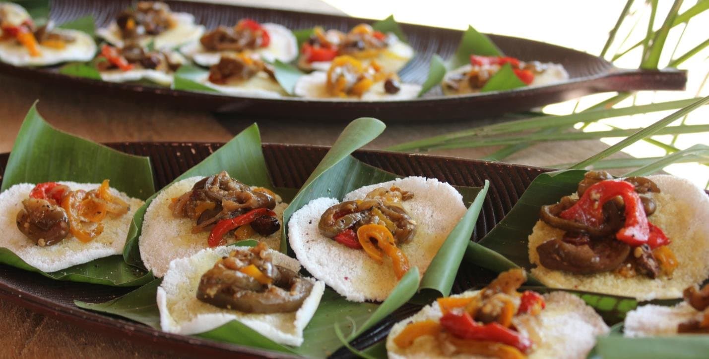 Regional flavours, thoughtfully arranged, the kitchen here takes local ingredients seriously. Small white cassava rounds topped with sautéed peppers and vegetables, arranged on banana leaves aboard an Amazon cruise from Alter do Chão