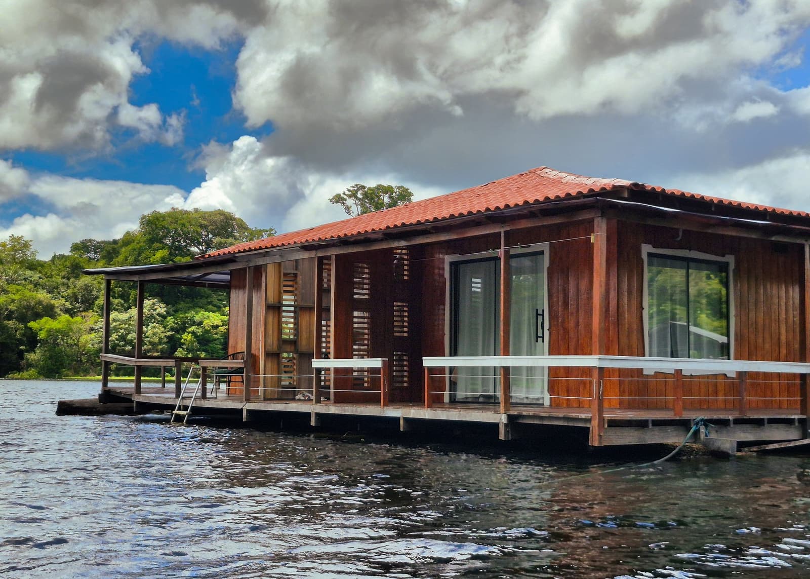 Your room for the night — a wooden cabin moored where the forest meets the river. Photo 4