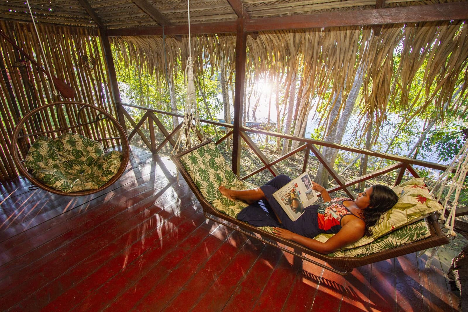 Pure jungle downtime — sunlight filtering through the palms while you swing and read. Photo: David Nascimento @ Photo 1