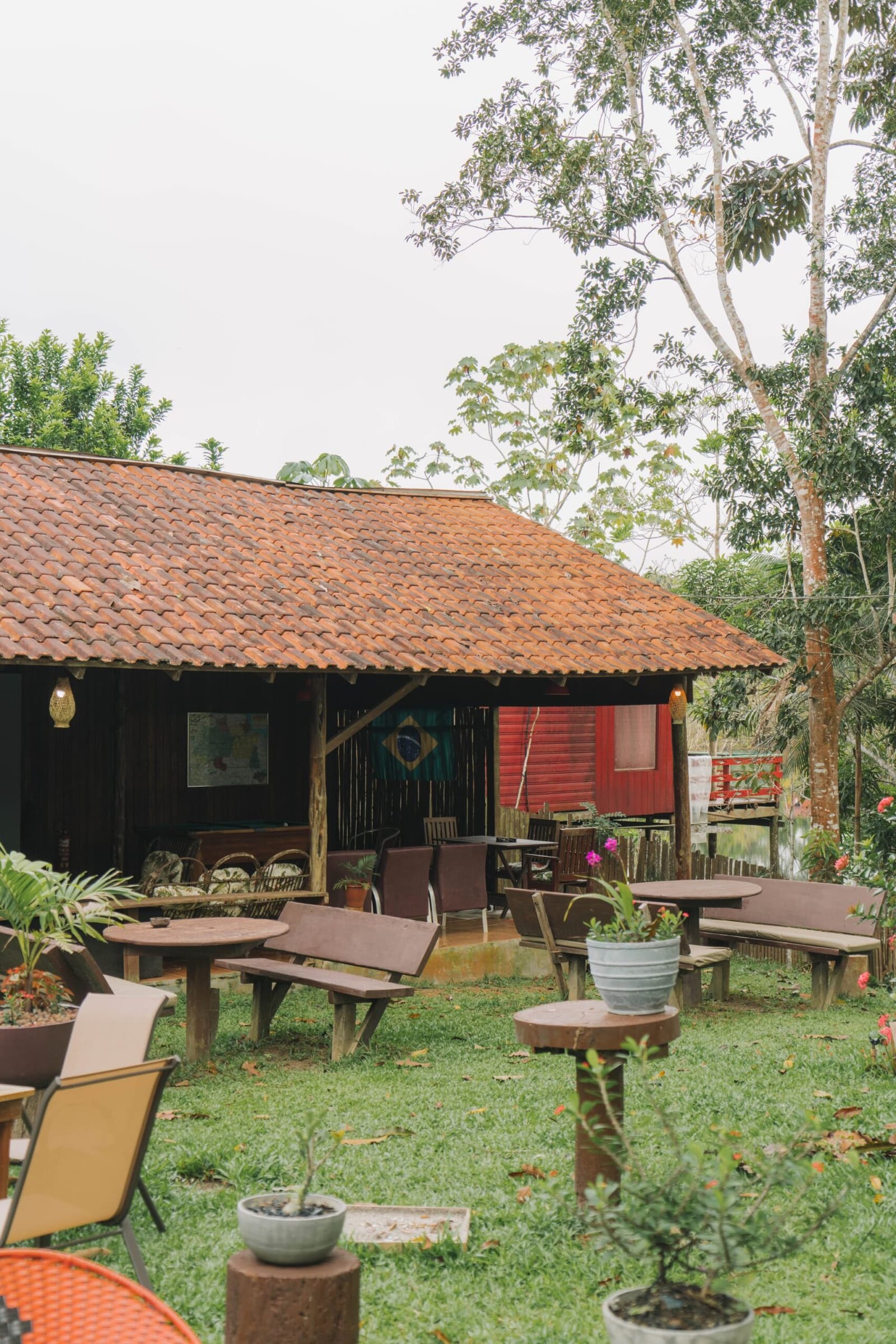 Wooden benches, potted flowers, and jungle trees all around — the lodge garden is yours to unwind in. Photo: Yuri Panichi Photo 7