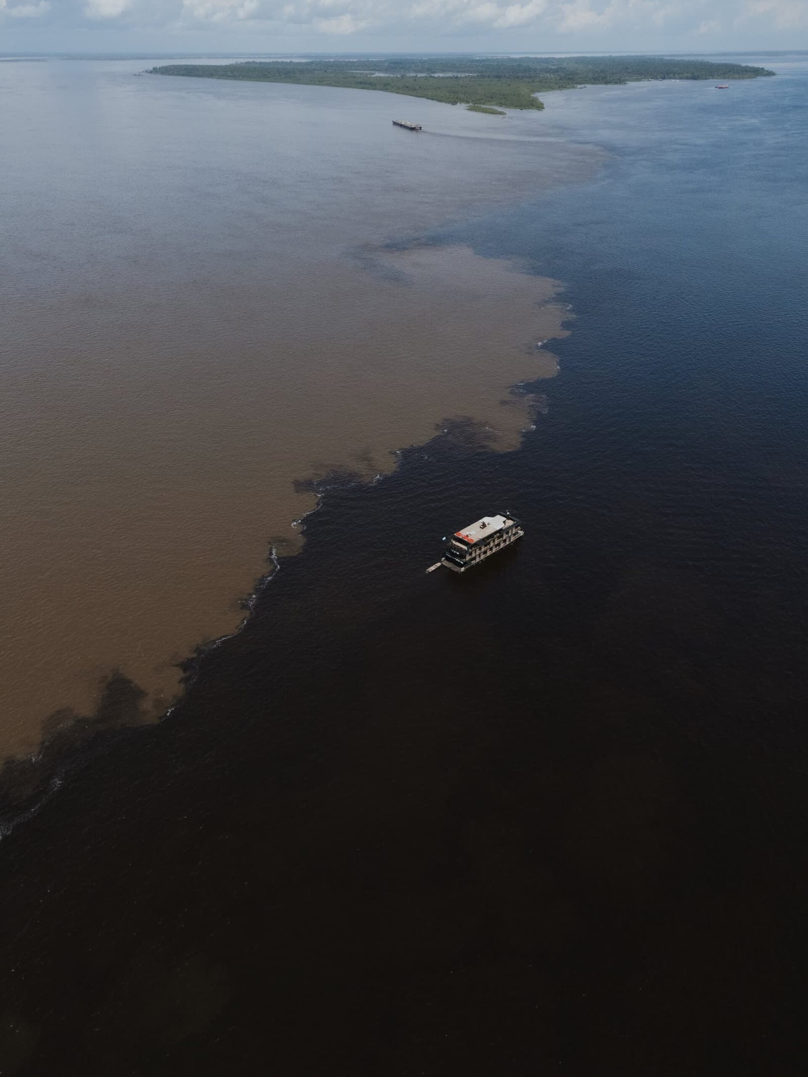 One boat, two rivers, zero mixing — nature's sharpest dividing line. Photo 2