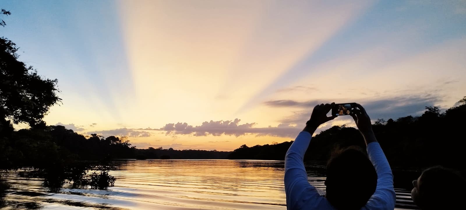 Crepuscular rays, golden water, and one phone that cannot put itself down. Photo 10