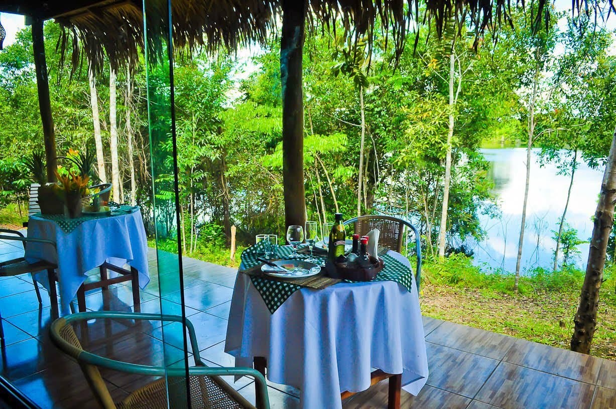 Dinner with a view — still water, tall trees, and a bottle of wine waiting. Photo 6