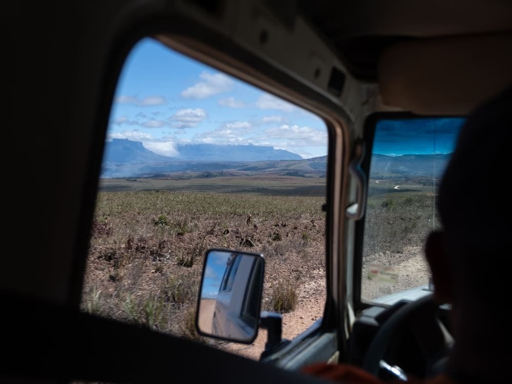 A 4x4 jeep transfer crossing the Gran Sabana with Mount Roraima in the distance A 4x4 jeep transfer crossing the Gran Sabana with Mount Roraima in the distance