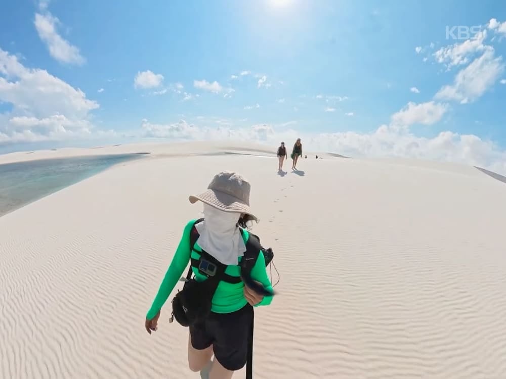 Photo: KBS Jihee Yeon trekking across the white dunes of Lençóis Maranhenses, with two hikers ahead