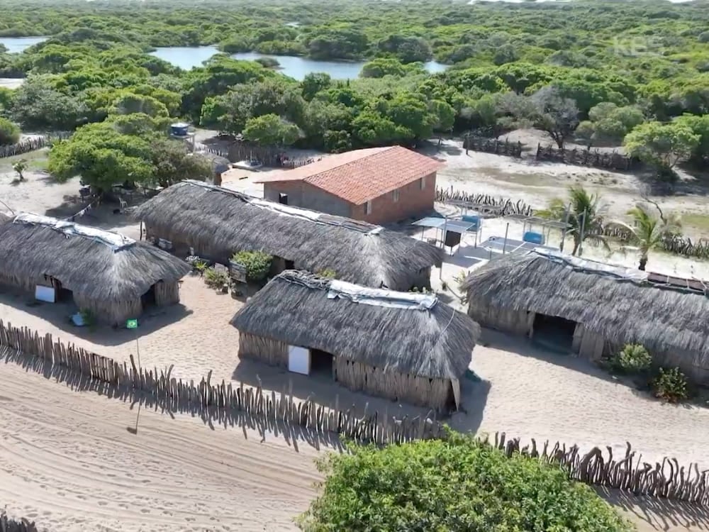 Photo: KBS Aerial view of thatched-roof houses in a village surrounded by greenery and lagoons in Lençóis Maranhenses