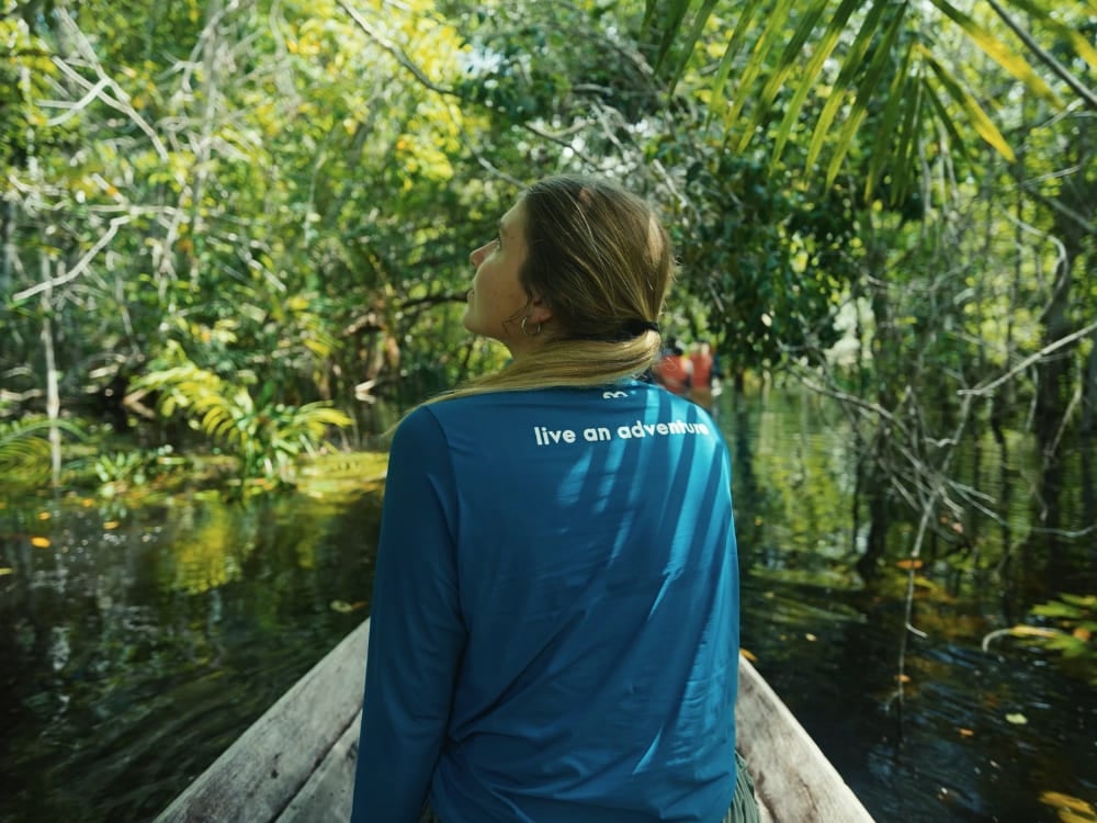 Photo: Marcelo Bonifácio Traveler in a canoe under the shade of the flooded forest canopy in the Brazilian Amazon