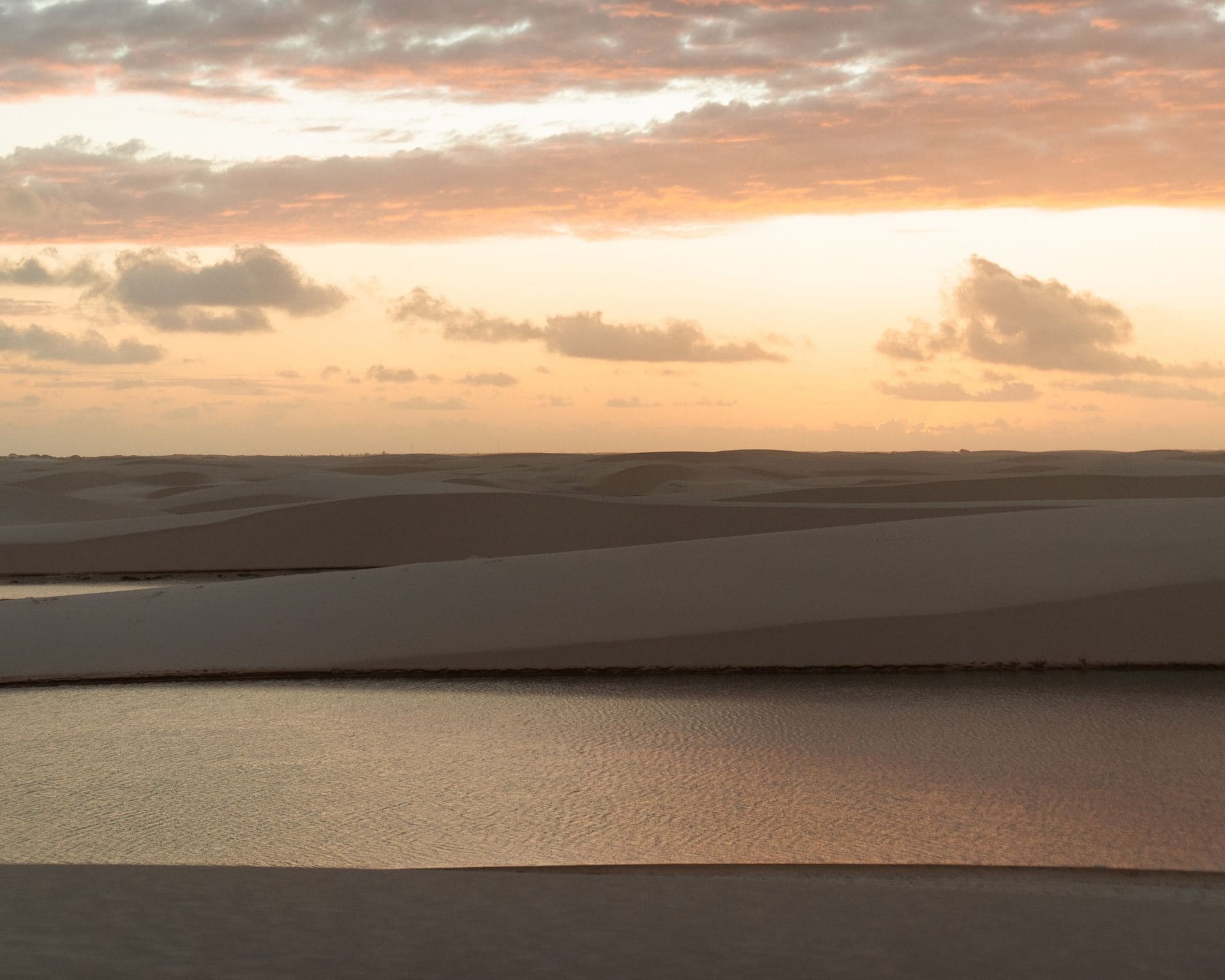 Pink sunset sky over the white sand dunes and a rainwater lagoon in Lençóis Maranhenses Pink sunset sky over the white sand dunes and a rainwater lagoon in Lençóis Maranhenses