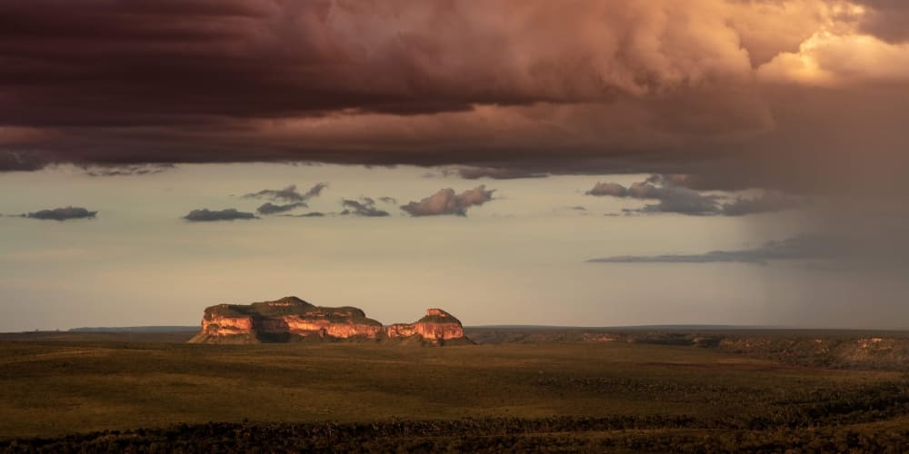 Dramatic sunset over a flat-topped rock formation in the vast Cerrado landscape of Jalapão, Brazil.