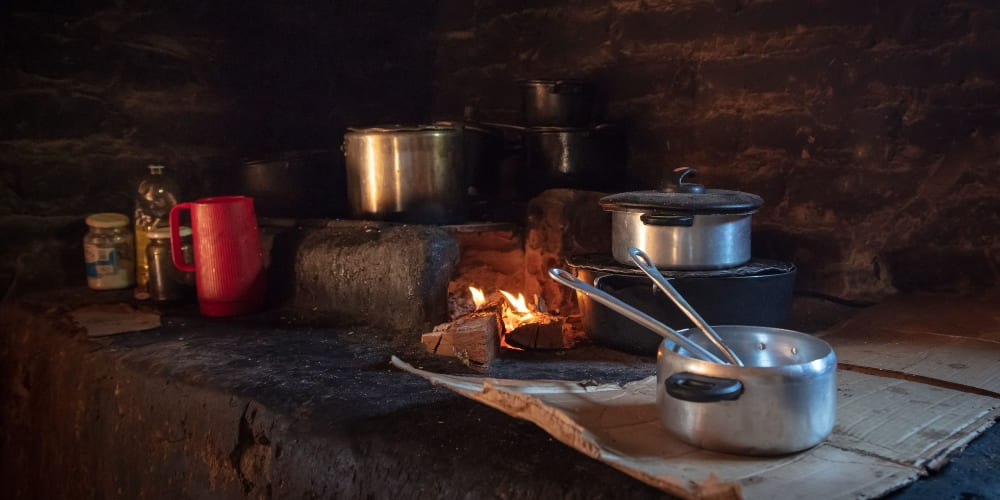 Aluminum pots cooking over an open fire on a traditional wood-burning stove in a Jalapão community.