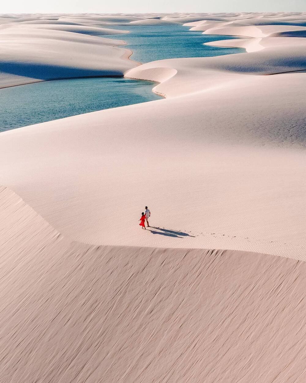 Couple qui marche dans les dunes du desert de Lençois Maranhenses 