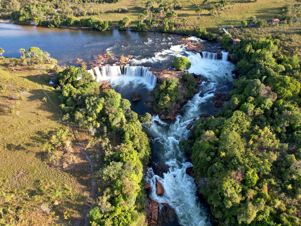 Aerial view of a wide waterfall cascading through lush green vegetation in Jalapão State Park.