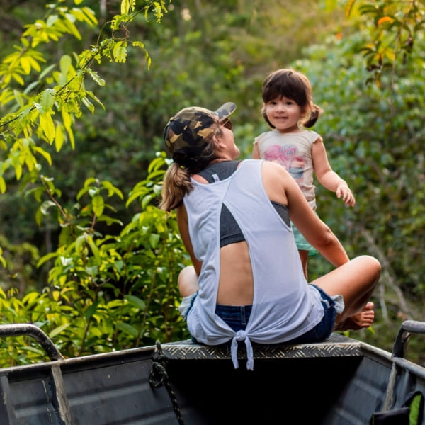 Woman and child sitting in a small metal boat during a river tour in the Amazon.