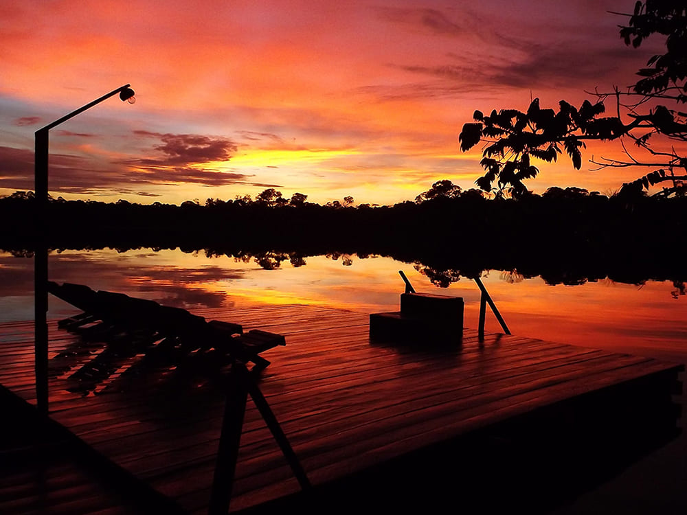Zonsondergang bij de rivier in de Amazone