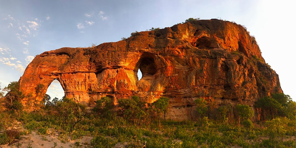 The sun sets behind Pedra Furada, an ancient sandstone formation with a hole in the middle in Jalapão, Brazil.