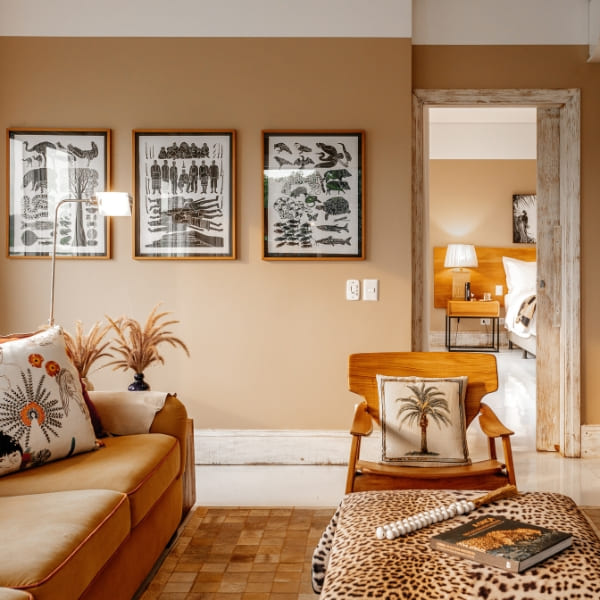 A comfortable living area in a Casa Caiman suite featuring a brown sofa and a jaguar print ottoman.