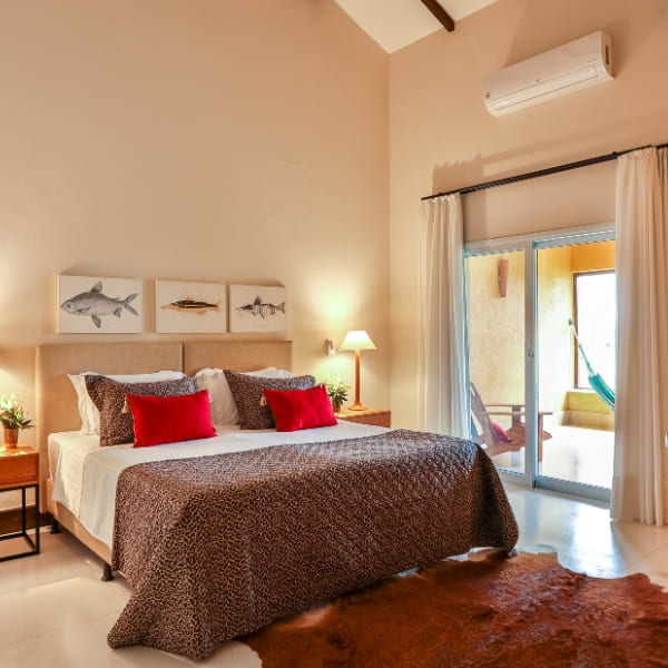 A comfortable suite at Casa Caiman featuring a king bed with an animal print blanket.