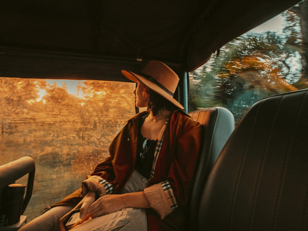 A woman looks out the window of a safari jeep at sunset during a Pantanal luxury vacation.
