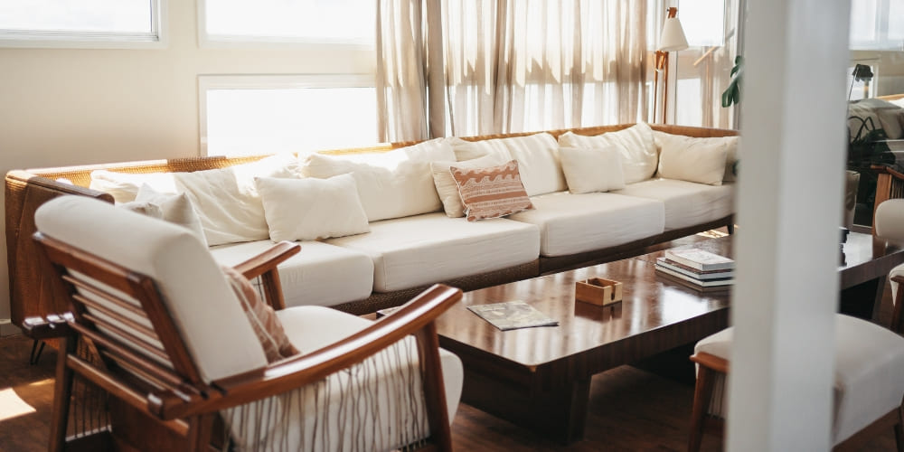 Guests can relax in the living room on the social floor, which features a long white sofa, wooden coffee table, and sophisticated decor.