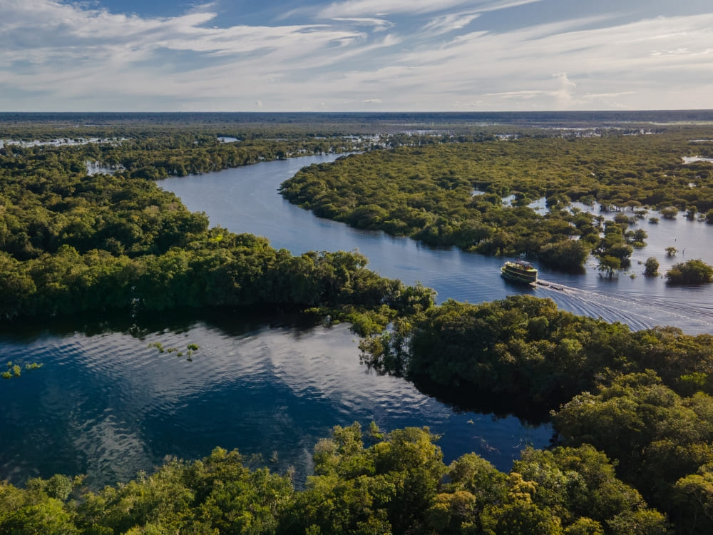 Aerial view of a winding blue river flowing through the dense green vegetation of the Amazon Rainforest in Brazil. Aerial view of a winding blue river flowing through the dense green vegetation of the Amazon Rainforest in Brazil.