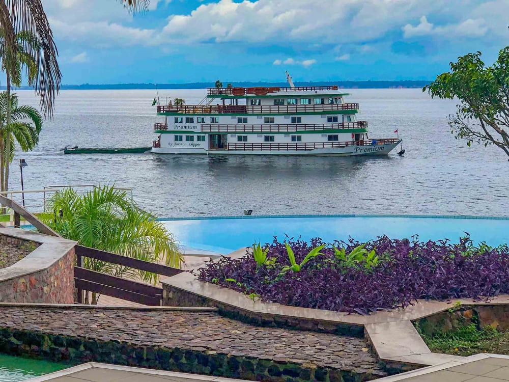 The Amazon Clipper Premium vessel docked near a riverside pool, offering a luxurious small-ship experience in the Amazon.