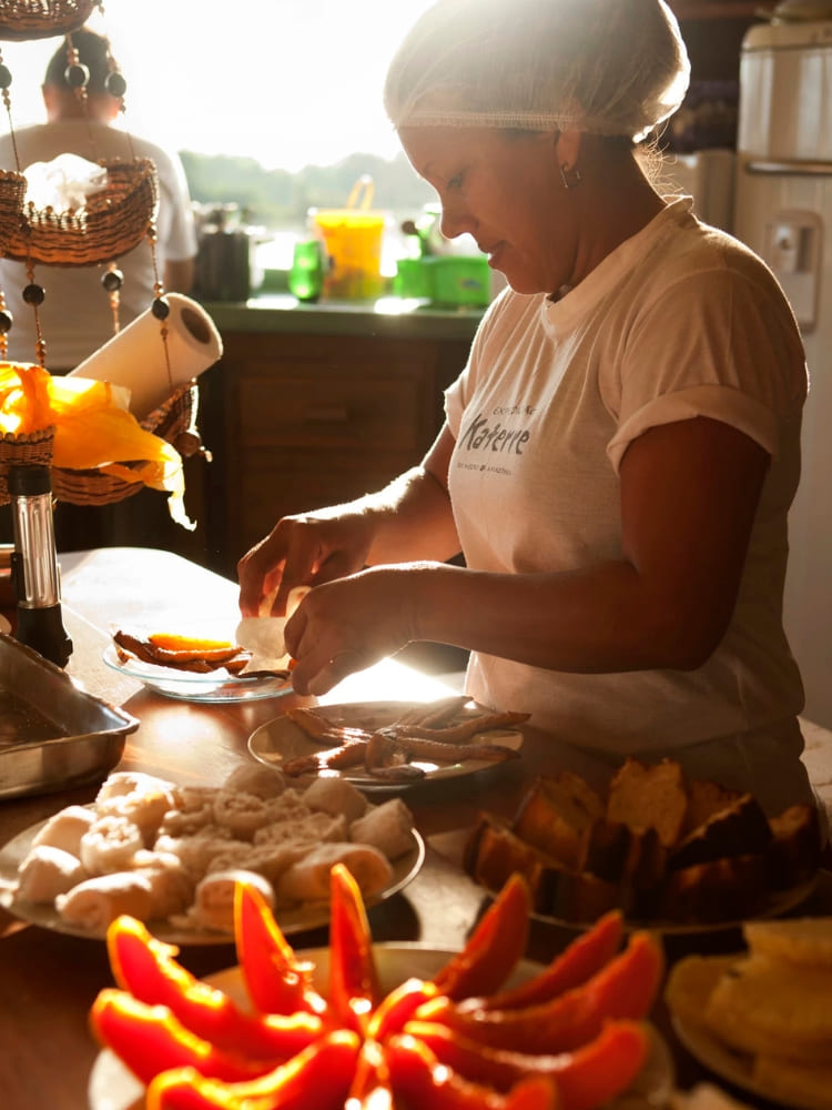 A chef preparing fresh local cuisine dishes with regional ingredients in the kitchen of an Amazon riverboat cruise.