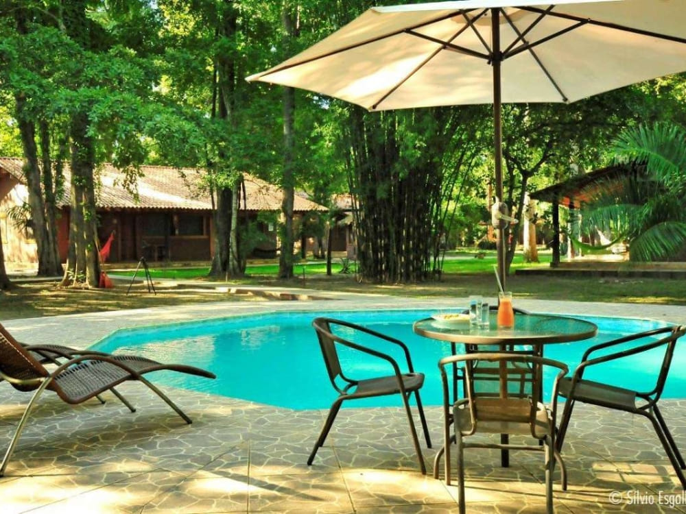 Lounge chairs sit beside the outdoor swimming pool at Aymara lodge, an ecological refuge surrounded by untouched nature. 