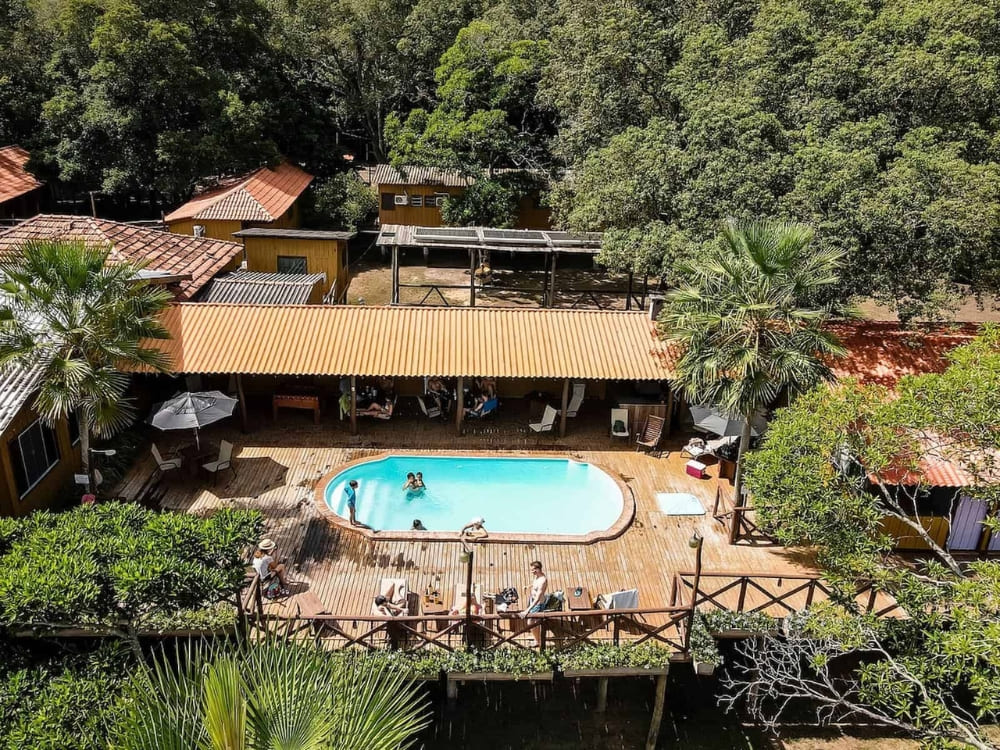 Guests swim in the outdoor pool on a wooden deck at the Pantanal Jungle Lodge near the Miranda River. 