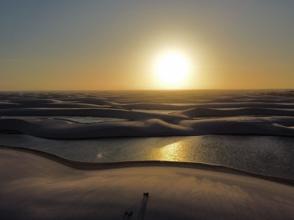 Le soleil se couche sur les dunes de sable blanc ondulantes et les lagunes d’eau de pluie du parc national des Lençóis Maranhenses.