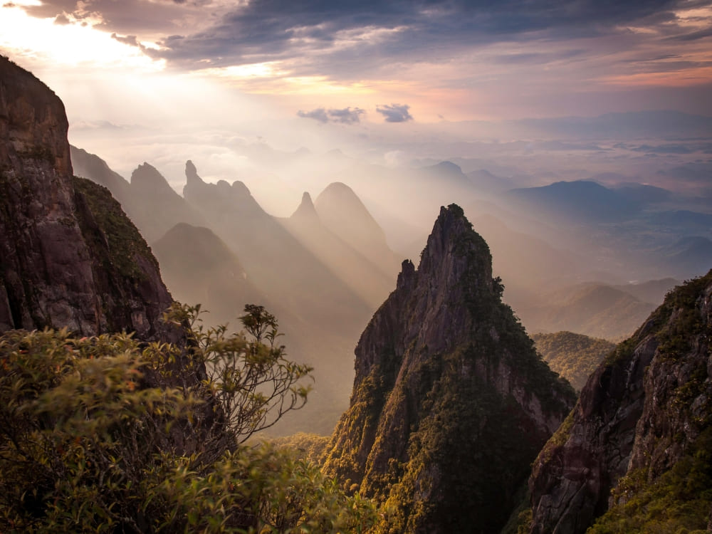 Misty sunrise over the jagged mountain peaks and trails of Serra dos Órgãos National Park in Brazil. 