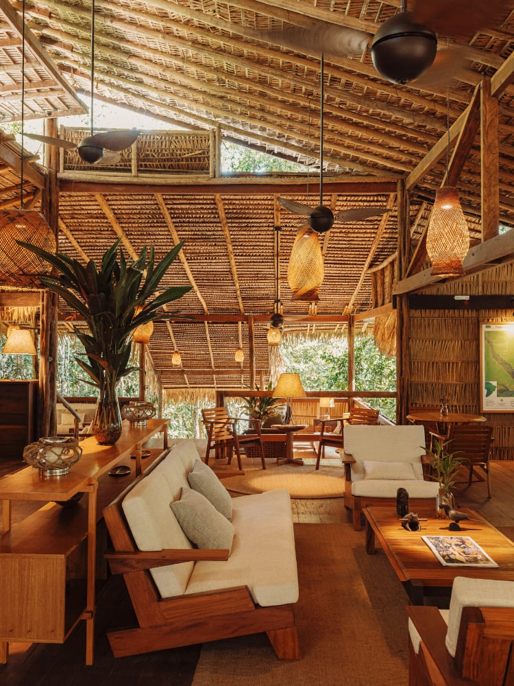A comfortable indoor lounge area with wooden furniture and warm lighting at Anavilhanas Jungle Lodge.