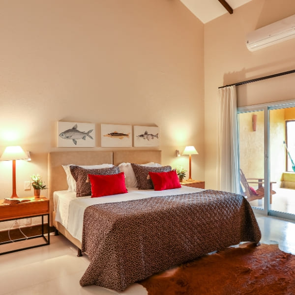 A modern, comfortable lodge bedroom with rustic decor, animal-print bedding, and a large glass door leading outside.