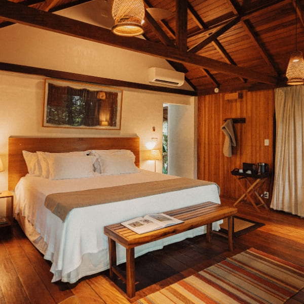 Spacious and comfortable suite in a jungle lodge, featuring wooden decor and amenities for a relaxing stay in the Brazilian Amazon.
