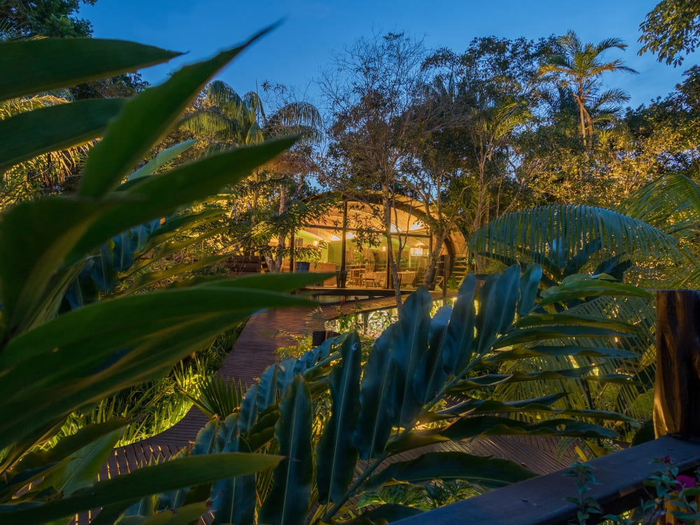 The illuminated wooden architecture of Mirante do Gavião at night, one of the best Amazon lodges in Brazil located near Anavilhanas National Park. 