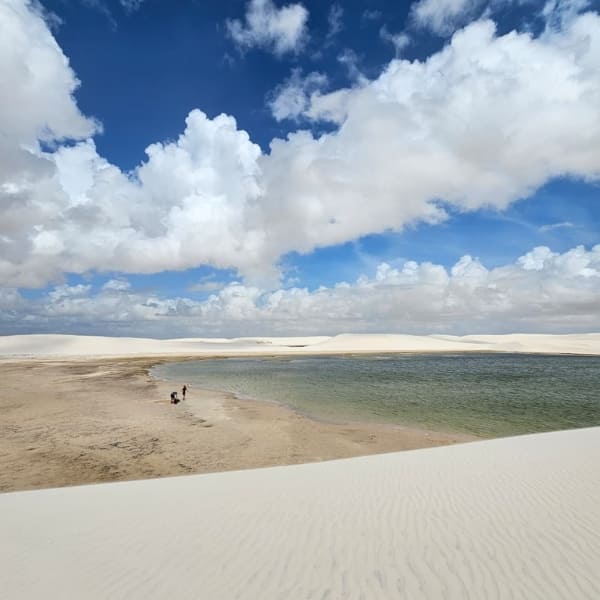 Weitläufige weiße Sanddünen und kristallklare Süßwasserlagunen unter blauem Himmel in Lençóis Maranhenses.