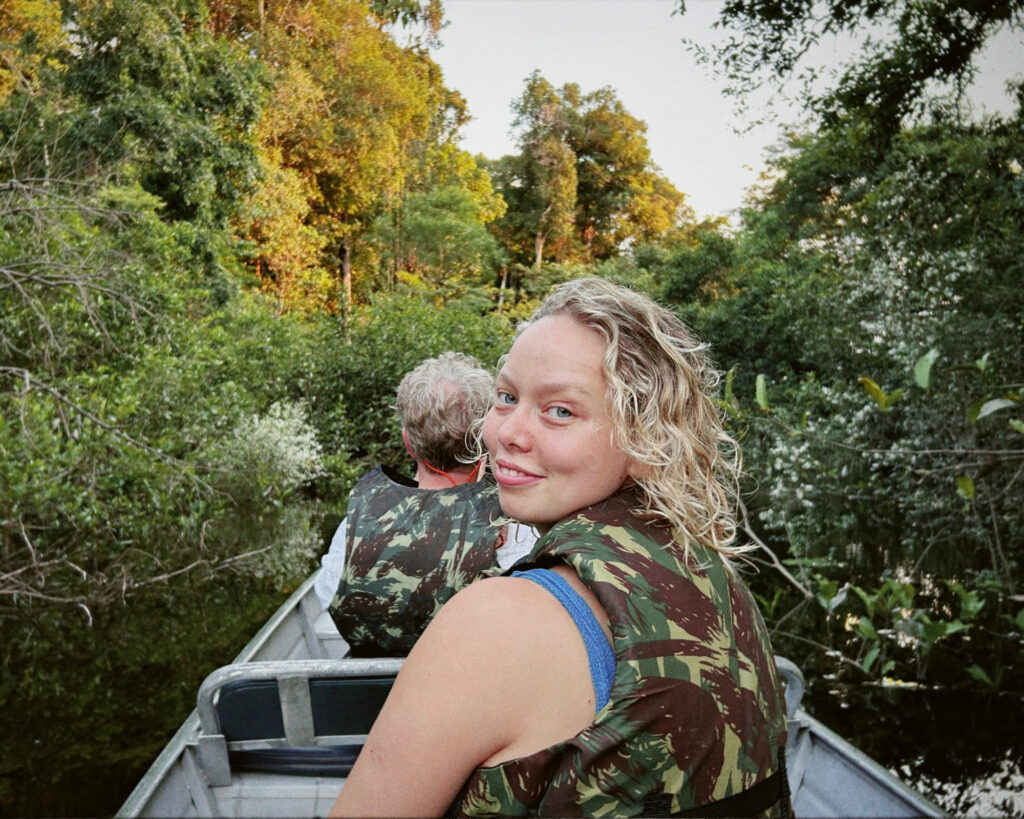 British writer Emma Phillips smiling in a small boat during a tour in the dense Amazon Rainforest.
