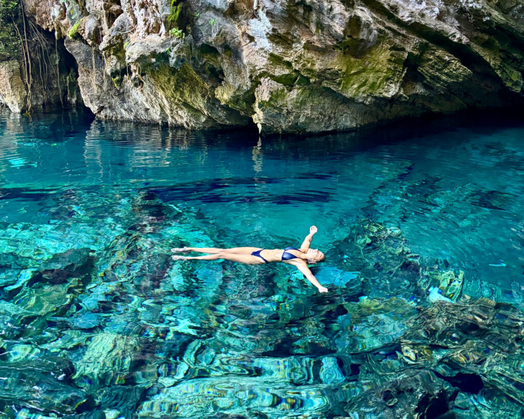 Samantha Sage floats peacefully on her back in the crystal-clear blue waters of the Japanese Lagoon in Jalapão, Brazil.
