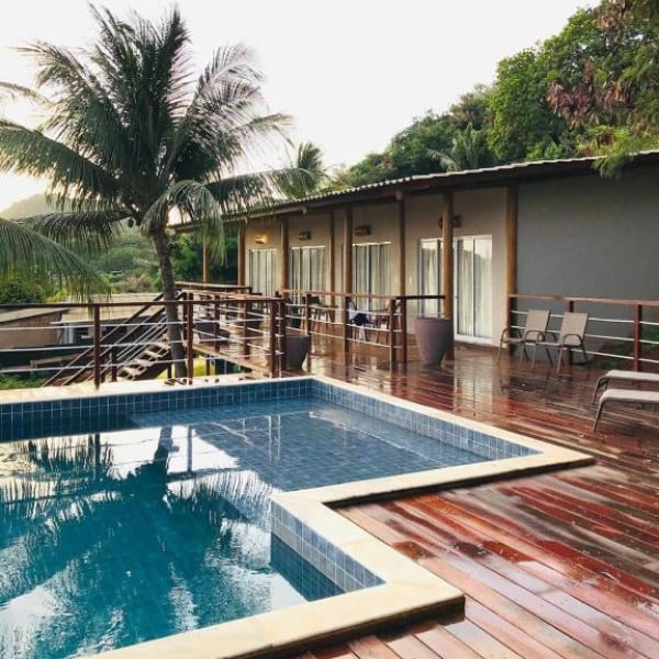 Square swimming pool built into a wet wooden deck overlooking tropical trees at an accommodation in Fernando de Noronha.